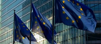 Три прапори, що відображуються у високій будівлі