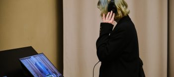 Дівчинка в навушниках у музеї дивиться відео на екрані