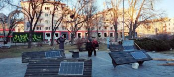 2024-02-01 AUSSTELLUNG Tschernihiw – Foto – Bänke mit Solar-Panels vor dem Hotel Ukraine zum Aufladen von Telefonen_Aushang