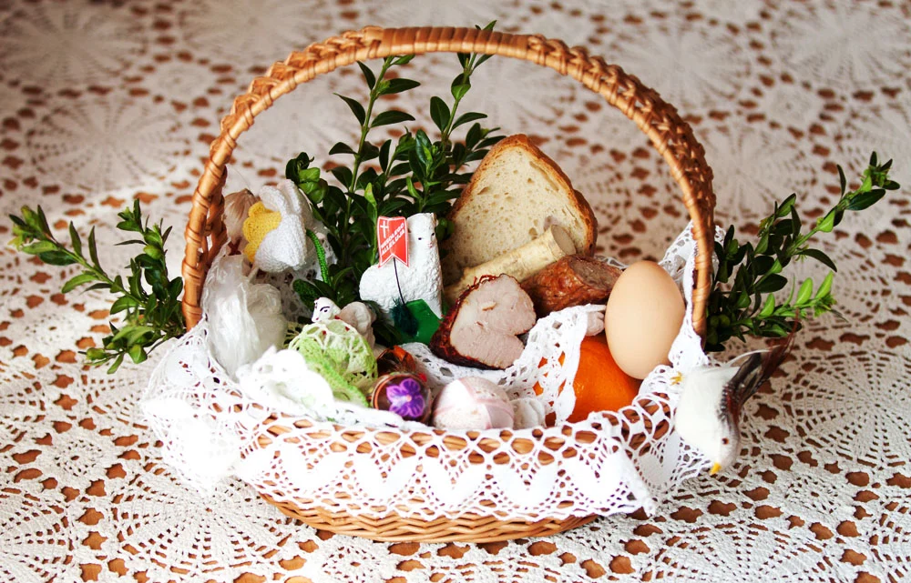 Panier de Pâques contenant du jambon, des saucisses, des œufs, un agneau en sucre et du raifort