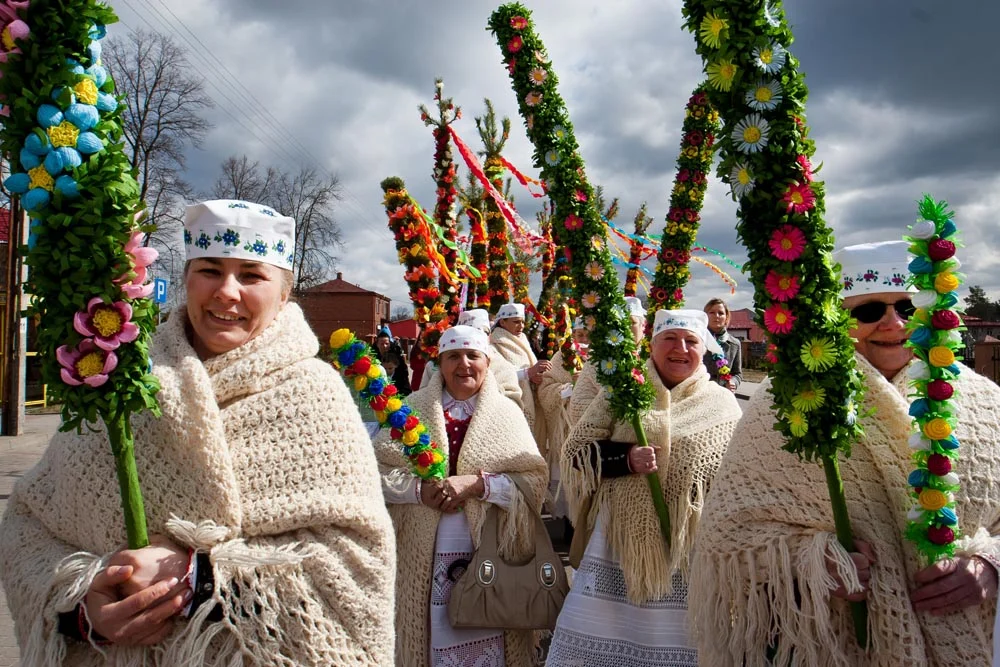 Des femmes portant des « rameaux » confectionnés à la main pour les faire bénir à l'église le dimanche des Rameaux