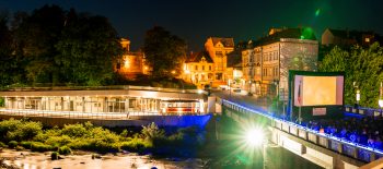 Fotografie z noční filmové projekce, jedná se o venkovní akci u řeky Olše.