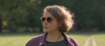 Na fotografii je básnířka Anna Adamowicz - mladá žena s polodlouhými vlasy a ve slunečních brýlích, je oblečena neformálně a na pozadí fotografie je louka a les.