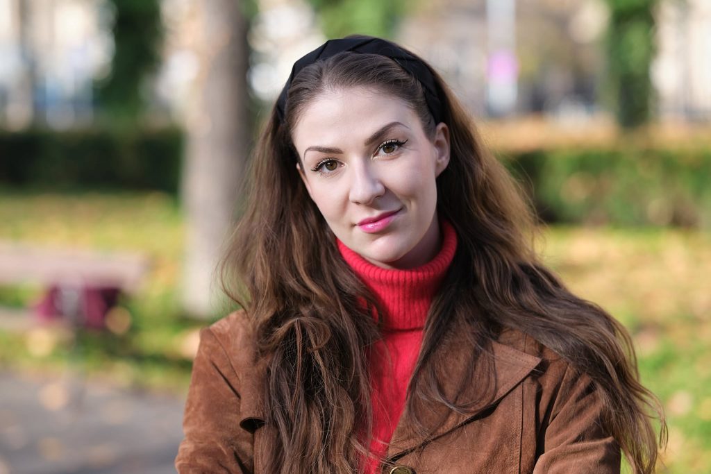 Básnířka Antonina Tosiek. Mladá žena s dlouhými vlasy, na pozadí park.